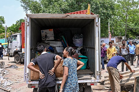 People transport their belongings amid a demolition drive in slum clusters near the Race Course in Lutyens' Delhi following a Delhi High Court order to clear the area and ensure the rehabilitation of residents.