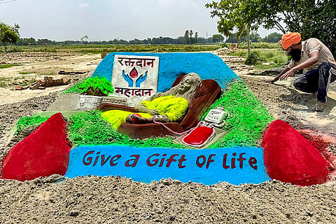 Artist Rupesh Singh makes a sand art on the World Blood Donor Day, in Ballia, Uttar Pradesh.