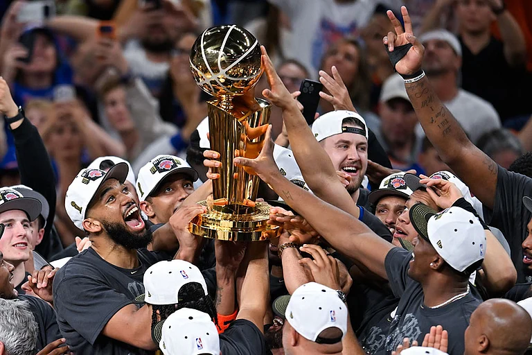 The New York Knicks celebrate with the Larry O'Brien Championship Trophy after defeating the San Antonio Spurs in Game 5 of the NBA Finals basketball series in San Antonio. - | Photo: AP/Darren Abate