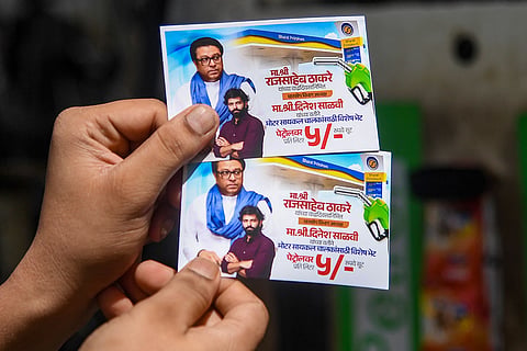 A MNS worker shows five rupees fuel discount coupons for two-wheeler riders on party chief Raj Thackeray’s birthday, in Mumbai.