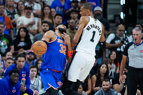 New York Knicks center Karl-Anthony Towns (32) tries to drive on San Antonio Spurs forward Victor Wembanyama (1) during the first half of Game 5 of the NBA Finals basketball series in San Antonio.