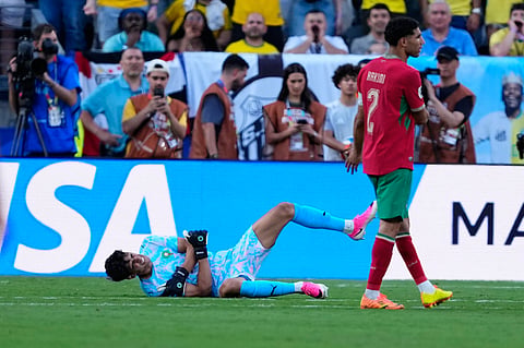 Morocco goalkeeper Yassine Bounou, left, grimaces in pain during the World Cup Group C soccer match between Brazil and Morocco in East Rutherford, N.J., near New York, Saturday, June 13, 2026.