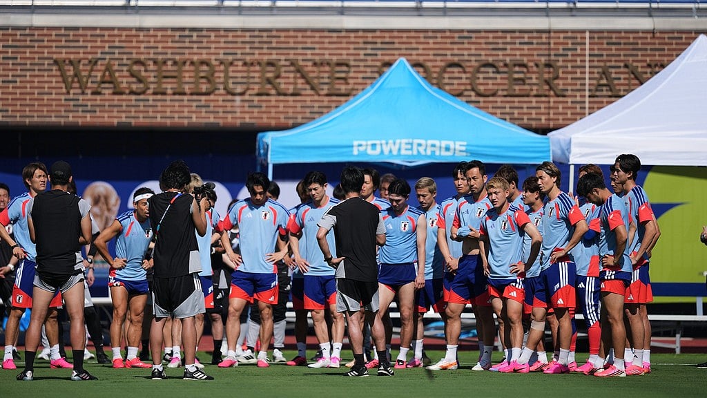 Japan head coach Hajime Moriyasu, center in black uniform, talks to his team during a training session ahead of their FIFA World Cup soccer tournament Group F match against the Netherlands. - AP Photo