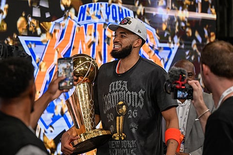 New York Knicks center Karl-Anthony Towns carries the Larry O'Brien Championship Trophy after defeating the San Antonio Spurs in Game 5 of the NBA Finals basketball series in San Antonio.