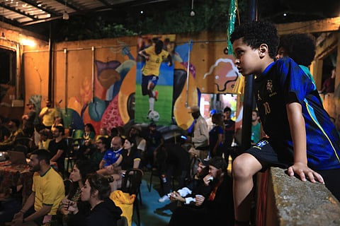 Fans watch the World Cup match between Brazil and Morocco at a housing occupation run by the Homeless Workers Movement, in Sao Paulo, Brazil, Saturday, June 13, 2026.