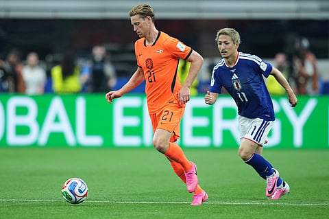 Netherlands' Frenkie de Jong (21) and Japan's Daizen Maeda chase the ball during a World Cup Group F soccer match in Arlington, Texas, near Dallas, Sunday, June 14, 2026.