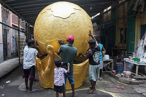 Artists prepare a 18 feet high replica of FIFA World Cup trophy made with sticks and papers, before sending it to Gangtok, amid the ongoing FIFA World Cup 2026, in Kolkata, West Bengal.