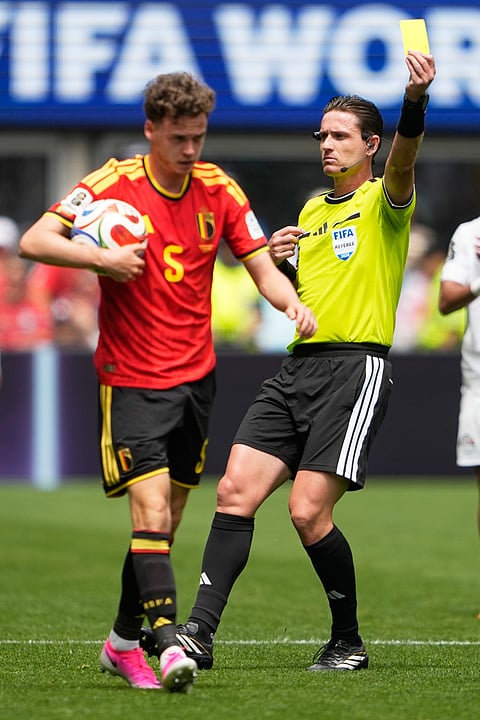 Referee Ramon Abatti of Brazil shows a yellow card to Belgium's Maxim De Cuyper during the World Cup Group G soccer match in Seattle, Monday, June 15, 2026.
