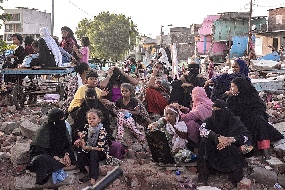 Residents sit amid debris in Surat