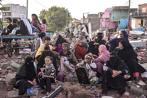 Residents remain amid the debris of demolished structures in Nasir Nagar, days after a demolition drive, in Surat, Gujarat.