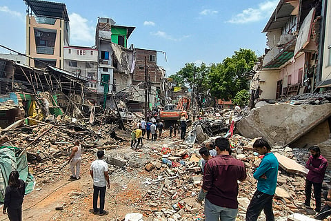 Residents look at the debris scattered around after authorities carry out a demolition drive, in Indore.
