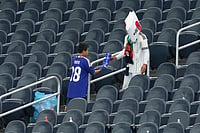 AP Photo/Tony Guttierez : Japanese fans collect trash after the World Cup Group F soccer match between the Netherlands and Japan in Arlington, Texas, near Dallas, Sunday, June 14, 2026.