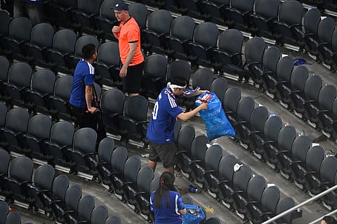 Japan fans clean up trash in the stadium following the World Cup Group F soccer match between the Netherlands and Japan in Arlington, Texas, near Dallas, Sunday, June 14, 2026.