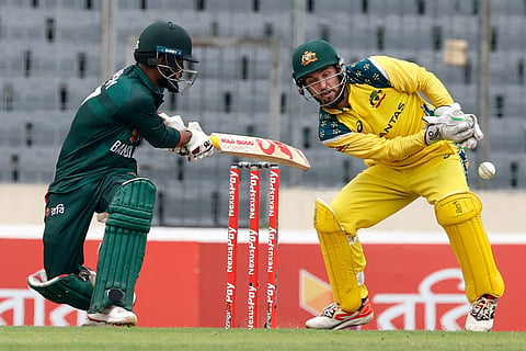 Bangladesh's Towhid Hridoy plays a shot as Australia's captain Josh Inglis reacts during the third one day international cricket match between Australia and Bangladesh, in Mirpur, Bangladesh.