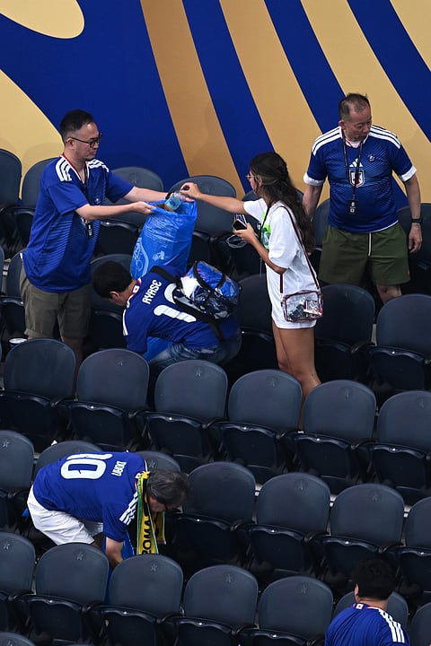 Japan fans clean up trash in the stadium following the World Cup Group F soccer match between the Netherlands and Japan in Arlington, Texas, near Dallas, Sunday, June 14, 2026.