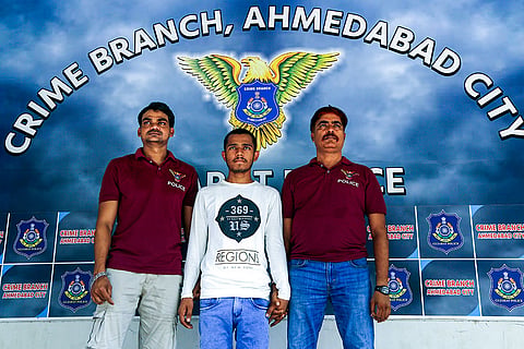 Personnel of the Ahmedabad Crime Branch with an accused arrested for allegedly attempting to divert refund amounts meant for NEET applicants to his own bank account, at the Crime Branch office, in Ahmedabad,. The accused was apprehended from Bihar's Gaya district.