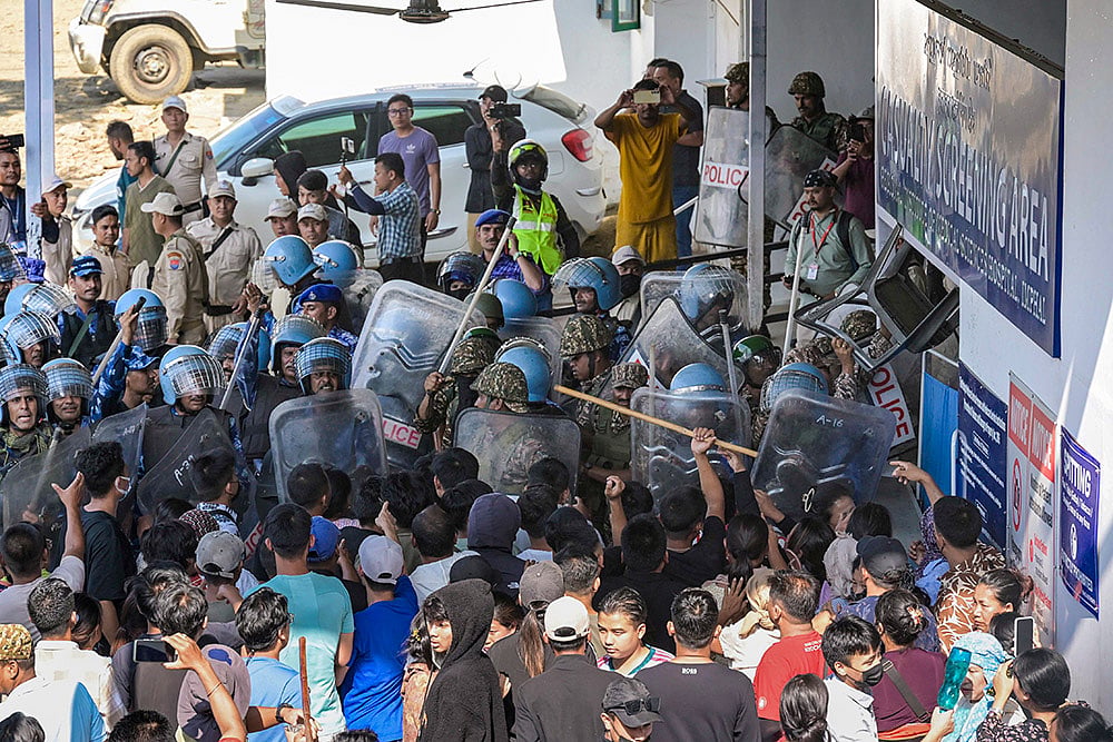 Security personnel stop protesters near the Regional Institute of Medical Sciences (RIMS), in Imphal. At least three persons were injured in an exchange of fire between two groups near Leilon Vaiphei village when armed persons belonging to two tribal communities exchanged fire in the Kuki-majority district. - | Photo: PTI 