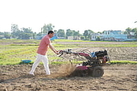 Uttarakhand Chief Minister Pushkar Singh Dhami operating a tiller in a field