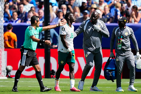Referee Alireza Faghani gestures for Senegal's Ismaila Sarr to leave the pitch to get medical assistance during the World Cup Group I soccer match between France and Senegal in East Rutherford, N.J., near New York, Tuesday, June 16, 2026.