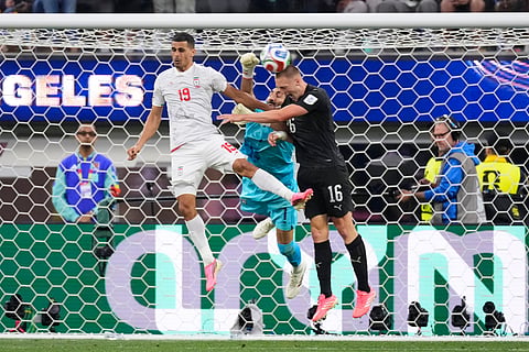 Iran goalkeeper Alireza Beiranvand (1) defends the goal alongside Ali Nemati (19) and New Zealand's Finn Surman (16) during the World Cup Group G soccer match between Iran and New Zealand in Inglewood, Calif., near Los Angeles, Monday, June 15, 2026.