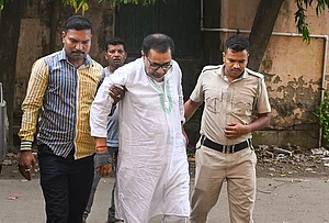 | Photo: PTI : Police personnel escort former West Bengal minister and Trinamool Congress (TMC) leader Ujjal Biswas to a district court following his arrest in connection with an alleged relief materials misappropriation case, in Nadia district, West Bengal.
