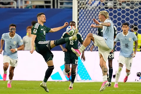 Uruguay's Guillermo Varela, right, and Saudi Arabia's Abdullah Alhamddan battle for the ball during the World Cup Group H soccer match in Miami Gardens, Fla., Monday, June 15, 2026.
