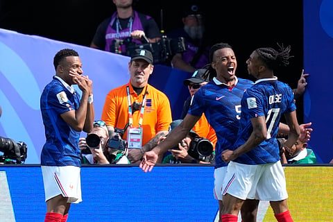 France's Kylian Mbappe, left, celebrates with teammates Jules Kounde and Michael Olise, right, after scoring the opening goal during the World Cup Group I soccer match between France and Senegal in East Rutherford, N.J., near New York, Tuesday, June 16, 2026.