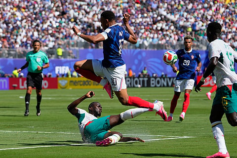 Senegal's Kalidou Koulibaly, on the ground, steals the ball from France's Kylian Mbappe during the World Cup Group I soccer match between France and Senegal in East Rutherford, N.J., near New York, Tuesday, June 16, 2026.