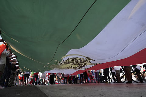 People unfurl a large Pre-revolutionary Iranian flags stand during a protest outside Los Angeles Stadium before the World Cup Group G soccer match between Iran and New Zealand in Inglewood, Calif., near Los Angeles, Monday, June 15, 2026.