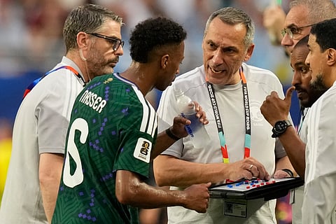 Saudi Arabia head coach Georgios Donis, right, talks to his player Nasser Aldawsari during the World Cup Group H soccer match against Uruguay in Miami Gardens, Fla., Monday, June 15, 2026.