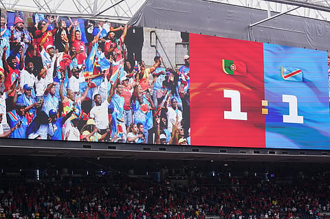 Celebrateing Congo fans are seen on a big screen after the World Cup Group K soccer match