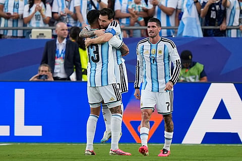 Argentina's Lionel Messi is congratulated by teammate Cristian Romero, left, as Rodrigo de Paul, right, watches after scoring his team's first goal during the World Cup Group J soccer match between Argentina and Algeria in Kansas City, Mo., Tuesday, June 16, 2026.