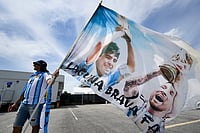 AP : Fabian Nunez of Corrientes, Argentina, holds a flag while waiting outside Kansas City Stadium for the World Cup Group J soccer match
