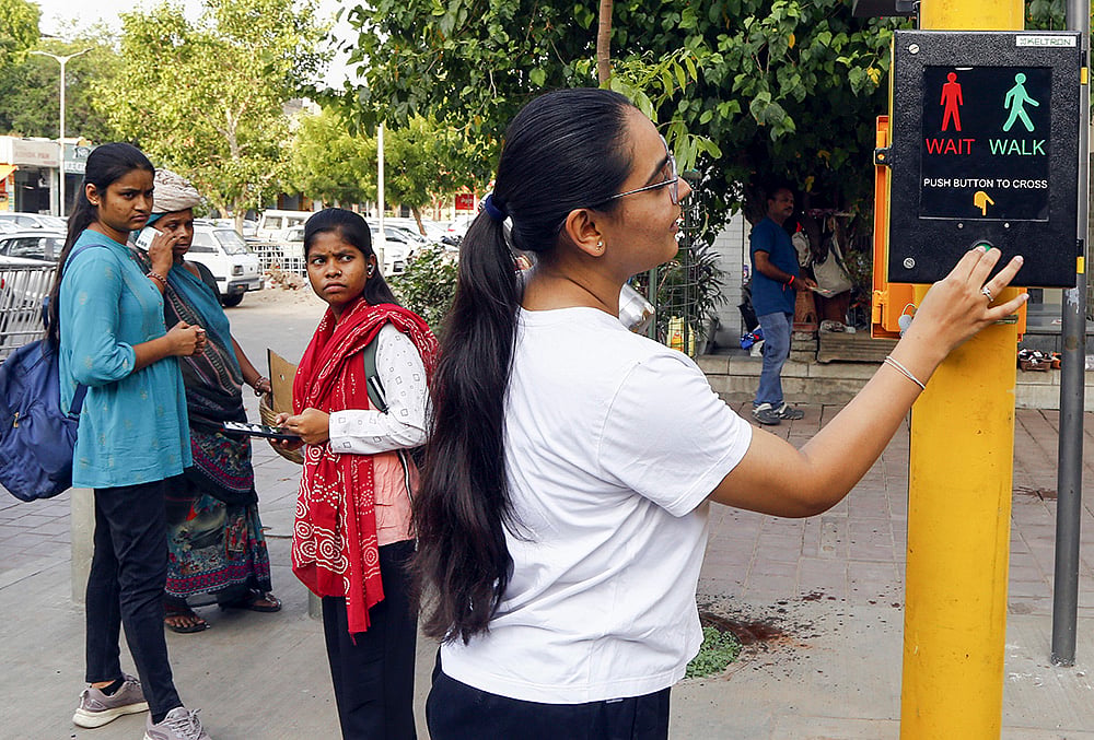A woman uses a pedestrian crossing signal