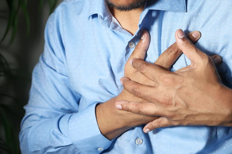 A man pressing on his chest during a heart attack