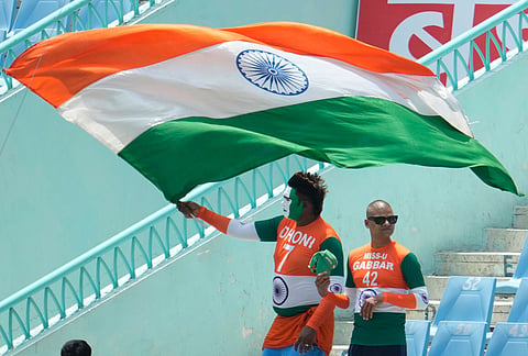 An Indian fan waves India's national flag during the second ODI cricket match between India and Afghanistan in Lucknow.