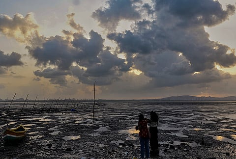 People gather at Sagar Vihar, an Arabian Sea water front in Vashi as clouds hover over during sunset, Navi Mumbai, Maharashtra.