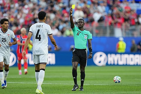 Referee Pierre Ghislain Atcho, of Gabon, show a yellow card to Iraq's Zaid Tahseen during the World Cup Group I soccer match between Iraq and Norway in Foxborough, Mass., near Boston, Tuesday, June 16, 2026.