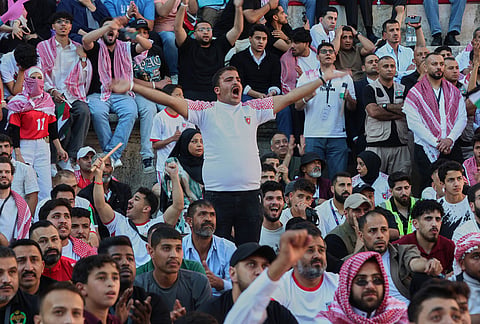 Jordanian soccer fans react while watching the World Cup match between Jordan and Austria on a large screen at the Roman Amphitheater in downtown Amman, Jordan.