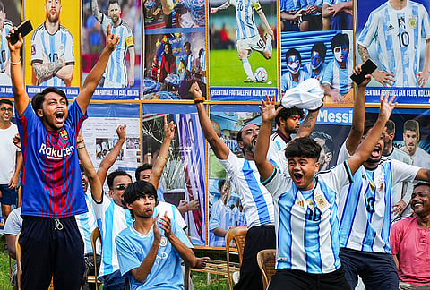 Argentina fans celebrate while watching a live screening after Lionel Messi scores a goal during the Group J FIFA World Cup qualifying match between Argentina and Algeria, in Kolkata.