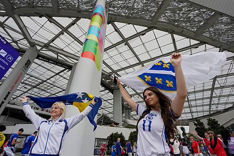 A fan of Switzerland holds a replica of a World Cup trophy ahead the World Cup Group B soccer match between Switzerland and Bosnia in Inglewood, Calif, near Los Angeles, Thursday, June 18, 2026.