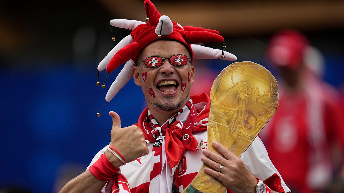 A fan of Switzerland holds a replica of a World Cup trophy ahead the World Cup Group B soccer match between Switzerland and Bosnia in Inglewood, Calif, near Los Angeles, Thursday, June 18, 2026. - (AP Photo/Gregory Bull)