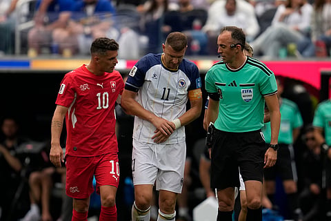 Switzerland's Granit Xhaka (10), left, and Referee Joao Pedro Silva Pinheiro, of Portugal, speaks to Bosnia's Edin Dzeko (11) after his was injured during the World Cup Group B soccer match between Switzerland and Bosnia in Inglewood, Calif, near Los Angeles, Thursday, June 18, 2026.