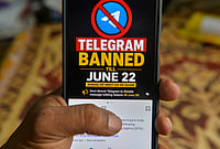 Day In Pics: June 18, 2026 | Photo: PTI : A man checks his mobile phone displaying information related to the temporary restriction on the messaging application Telegram ahead of the NEET-UG re-examination, in Siliguri, West Bengal.