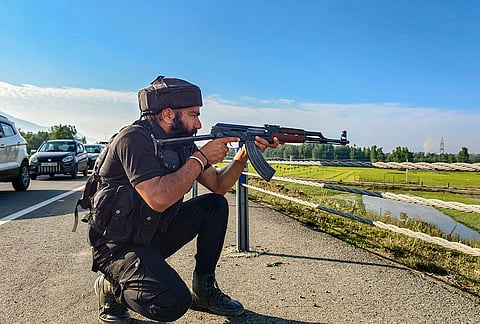 A security personnel participates in a mock drill ahead of the Shri Amarnath Ji Yatra 2026, along the Srinagar-Jammu National Highway at Kakapora, in Pulwama district.