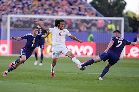 Morocco's Ayyoub Bouaddi, centre, lunges for the ball with Scotland's John McGinn during the World Cup Group C soccer match between Scotland and Morocco in Foxborough, Mass., near Boston, Friday, June 19, 2026.