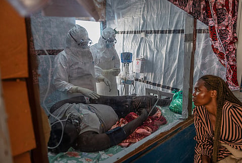 Health workers tend to an Ebola patient at the Rwampara Treatment Center in Ituri, Congo.