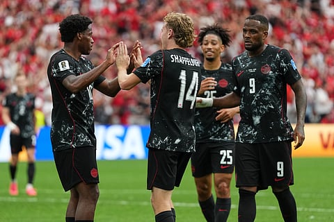 Canada's Jonathan David, left, celebrates with teammates after scoring his side's sixth goal for a hat trick during the World Cup Group B soccer match against Qatar in Vancouver, British Columbia, Thursday, June 18, 2026.