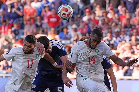 Scotland's Grant Hanley, centre, attempts to head the ball under pressure from Morocco's Ismael Saibari, left, and Issa Diop during the World Cup Group C soccer match between Scotland and Morocco in Foxborough, Mass., near Boston, Friday, June 19, 2026.