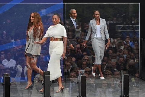 Former President Barack Obama, back center, and former first lady Michelle Obama, right, arrive on stage with their daughters, Sasha and Malia Obama, during the dedication ceremony for the Obama Presidential Center.